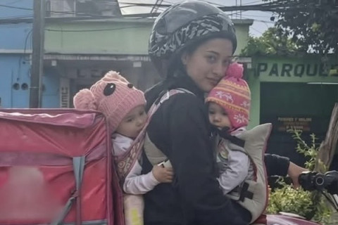 Mãe viraliza ao trabalhar como entregadora enquanto cuida dos dois filhos