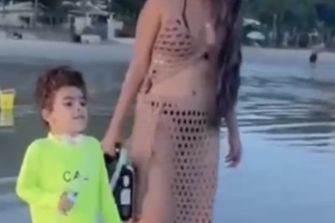 Carregando o oxigênio do filho pela areia, mãe realiza sonho e o leva para ver o mar.